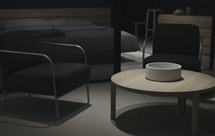 A low table with two chairs in a low light bedroom
